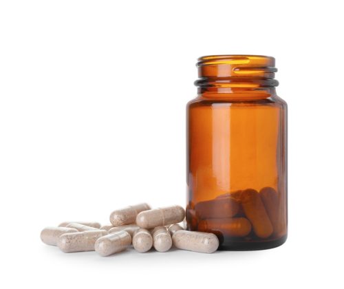 Gelatin capsule and bottle on white background