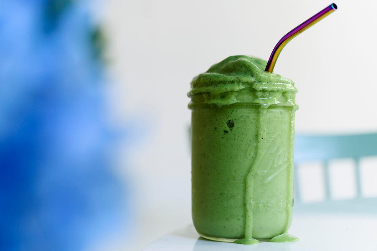 Bright green smoothie in a glass jar.